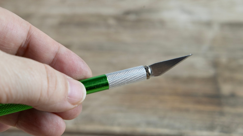 A craft knife used for repairing veneer on antique furniture