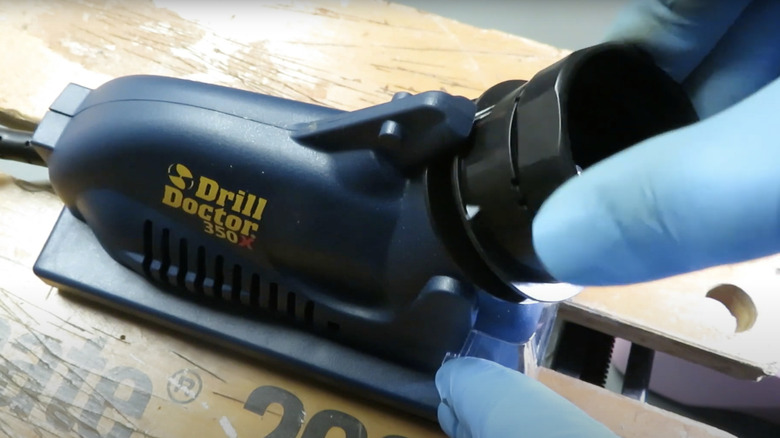 Person using the Drill Doctor 350X drill bit sharpening machine to sharpen a bit