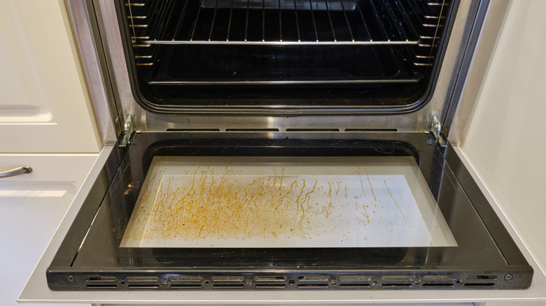 Open oven with dirty glass on the door