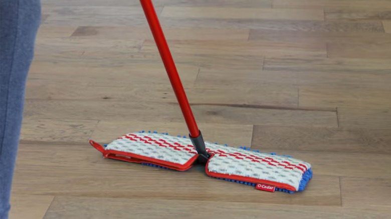 A person cleaning a wood floor with a  O-Cedar Hardwood Floor 'N More 3-Action Mop