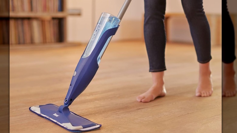 A person mopping a wood floor with a Bona Hardwood Spray Mop