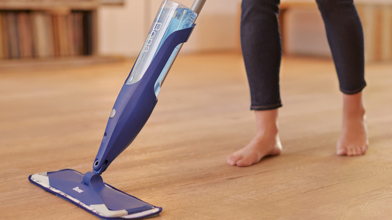 A person mopping a wood floor with a Bona Hardwood Spray Mop