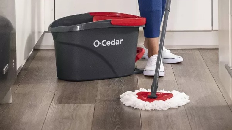 A person mopping a hardwood floor with an O-Cedar EasyWring Spin Mop