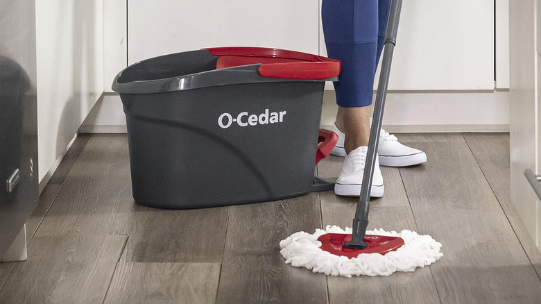 A person mopping a hardwood floor with an O-Cedar EasyWring Spin Mop