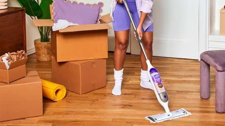 A person cleaning a wood floor wiht a Swiffer Power Mop Wood