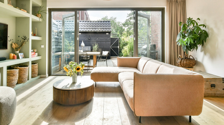 A living room with planters opening up to a small backyard and garden