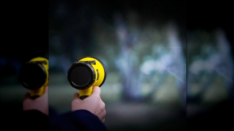 person using BRAUN flashlight in dark`