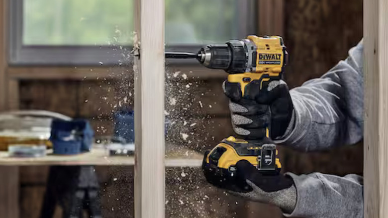 Dewalt drill being used to make hole in wooden beam