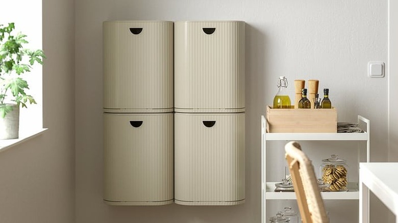 Beige storage bins from IKEA are mounted to the wall in a modern kitchen.
