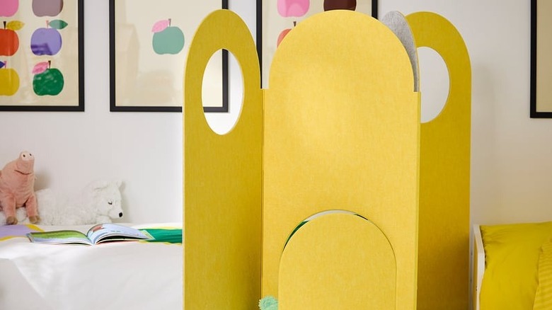 A yellow room divider anchors the space in a child's room.