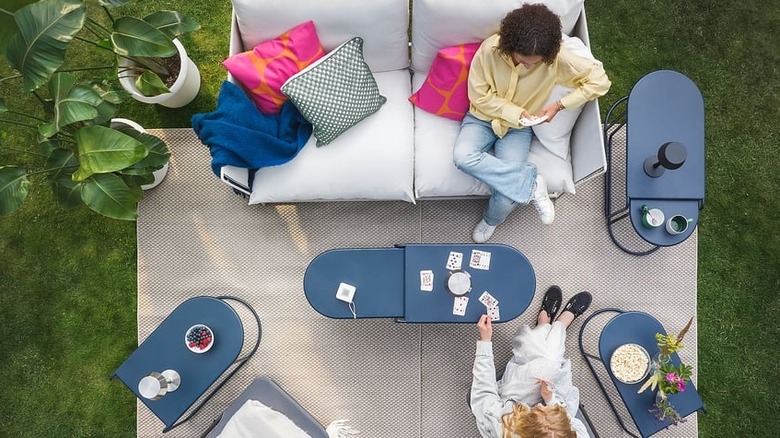 Blue nesting tables are out in an outdoor lounging space.