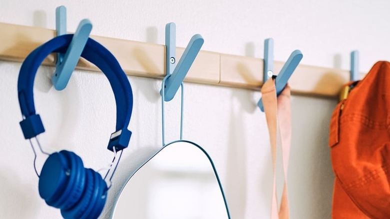 A birch rack holds headphones, a mirror and clothes.