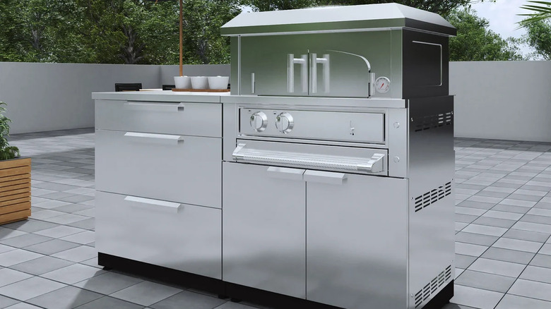 A stainless steel outdoor kitchen with a pizza oven.