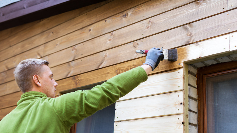 man staining exterior trim