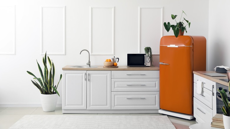 Orange refrigerator in kitchen corner