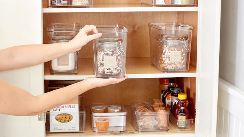 Hands placing bin on shelf