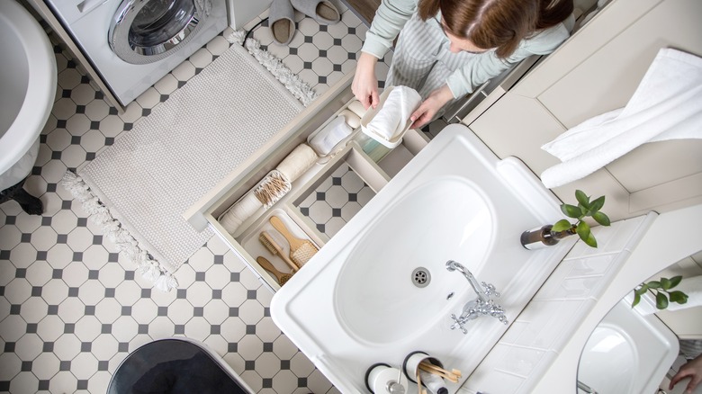 woman organizing bathroom vanity drawer