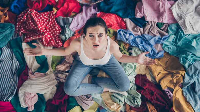 person in pile of clothes