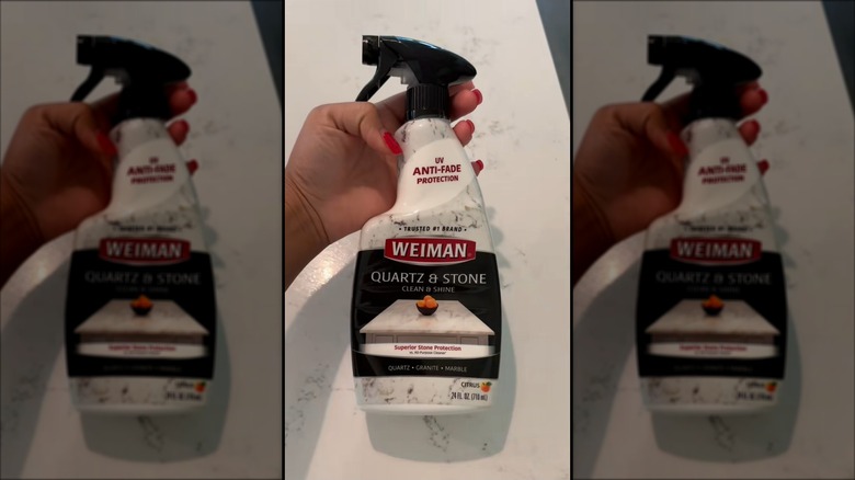 Person holding a spray bottle of Weiman quartz countertop cleaner