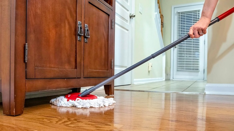 a man mopping the floor with O-Cedar EasyWring Microfiber Spin Mop