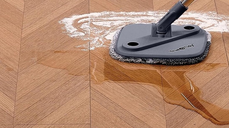 a True & Tidy True Clean Spin Mop cleaning spilled water on a floor
