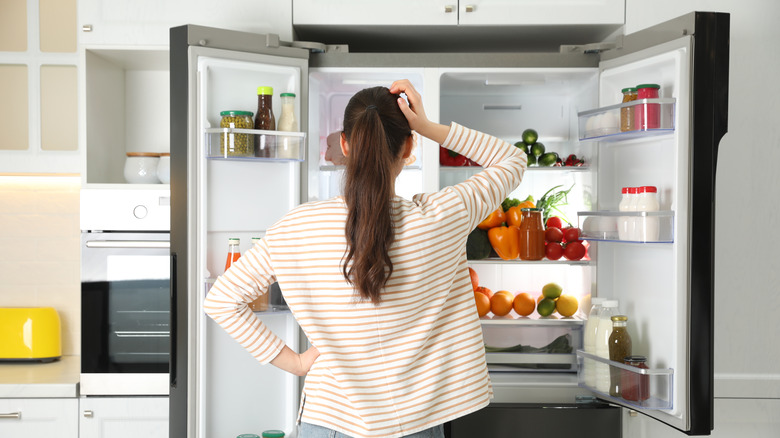 woman looking into refrigerator