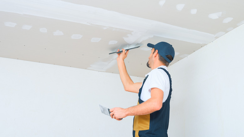 Man painting ceiling