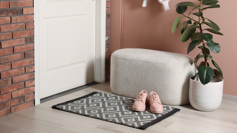 gray ottoman by entry way