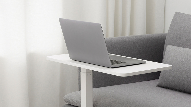 An IKEA BOLLSIDAN Laptop Stand next to a couch