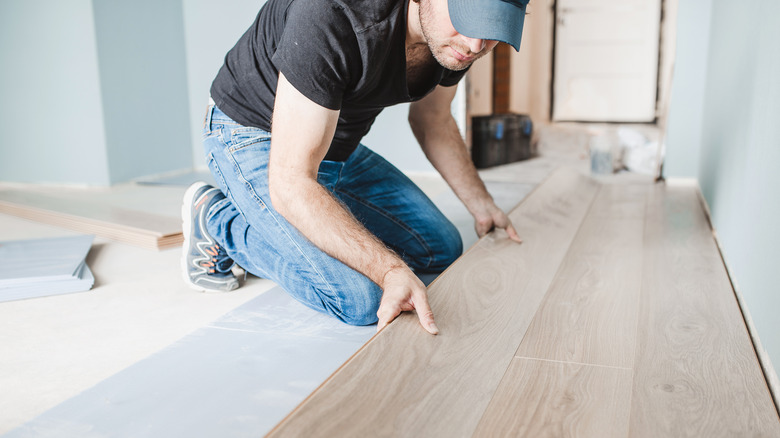 Man lining up flooring panel