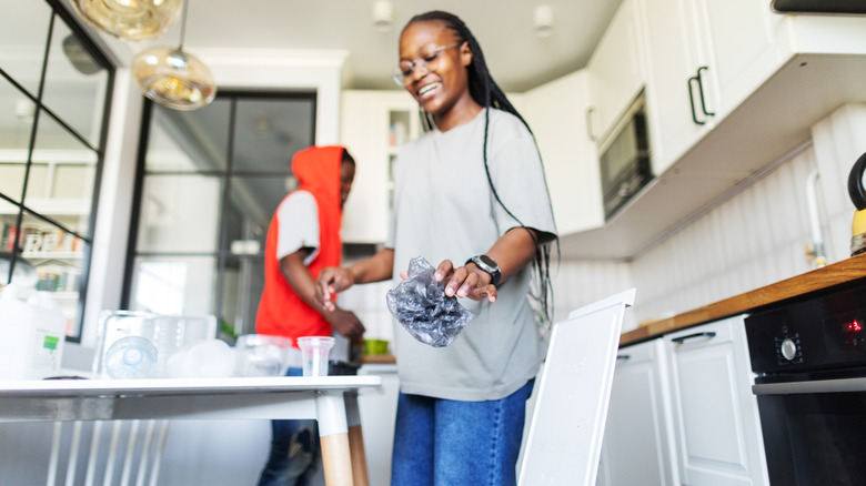 Two people sort waste to prepare for spring cleaning their kitchen