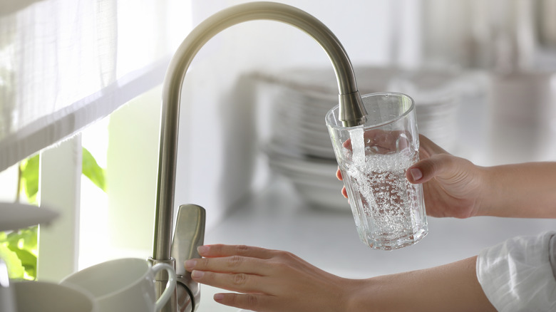 A woman getting water from a tap