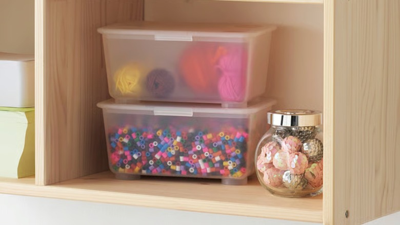 IKE GLIS bins on a wood shelf holding beads and yarn