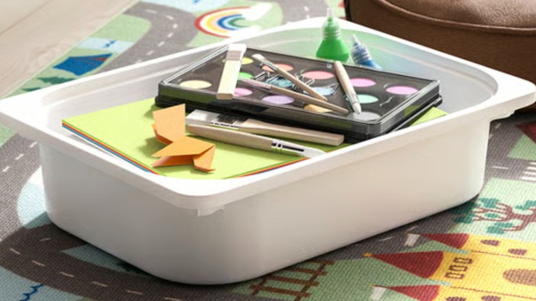 A white IKEA TROFAST bin holding art supplies