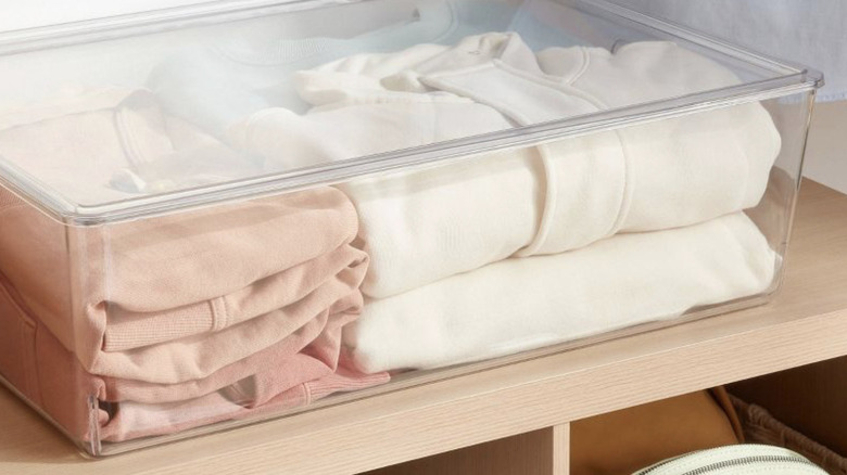 Target Brightroom's Stackable Clear Bin with Lid holding sweatshirts on a closet shelf
