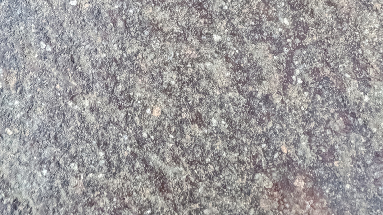 A shiny gold heart sticker on a natural stone countertop.