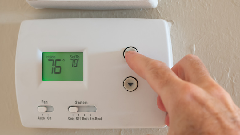 Person adjusting thermostat