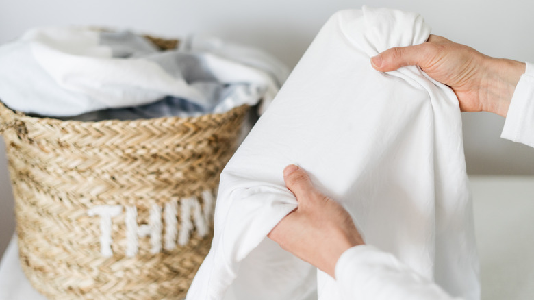 Person holding a white t-shirt