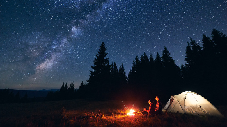 fire and tent under stars