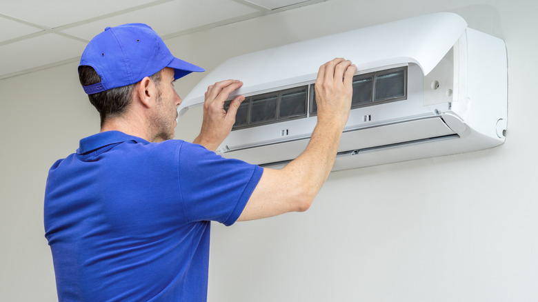Hvac technician performing heat pump maintenance inspection.