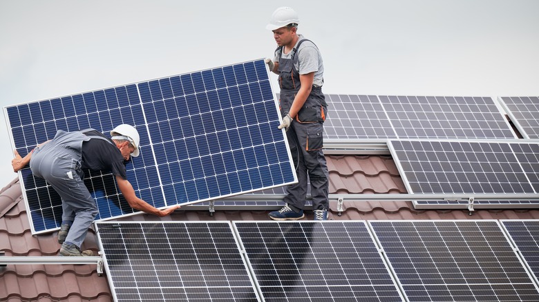 Professionals installing rooftop solar panels
