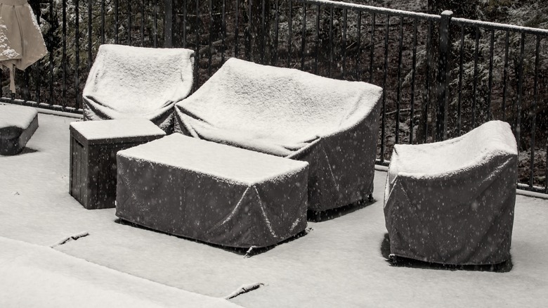 outdoor furniture with snow on its protective covers