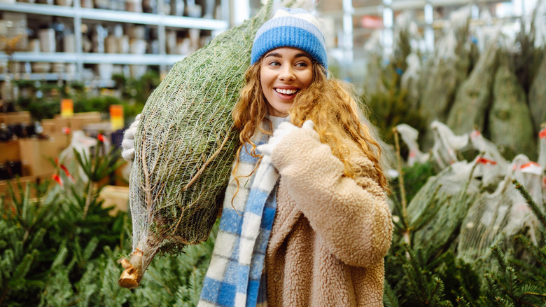 Woman buying a live Christmas tree.