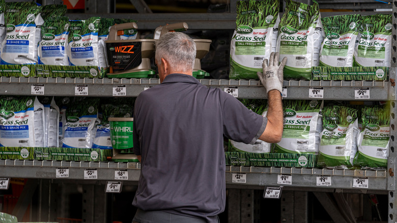 Man stocking grass seed bags