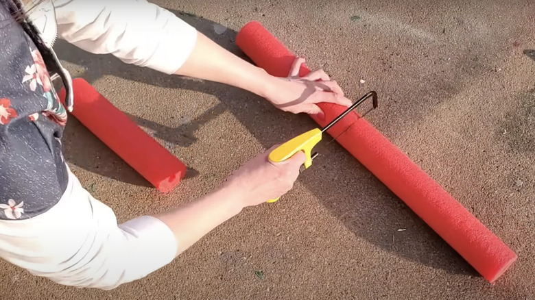 person cutting a pool noodle