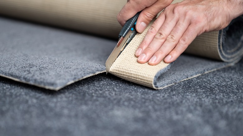 person cutting a carpet