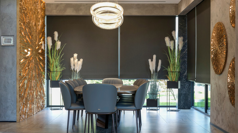 Dark shade screens automatically lower on sliding glass doors in a dining room.