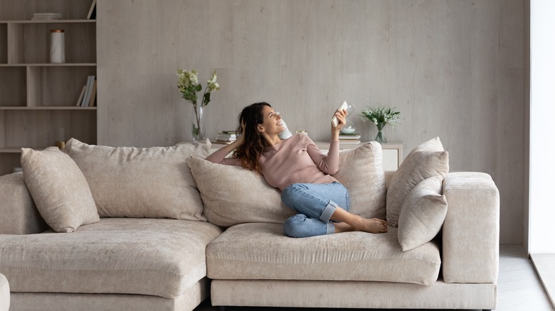 Woman laying on a beige couch