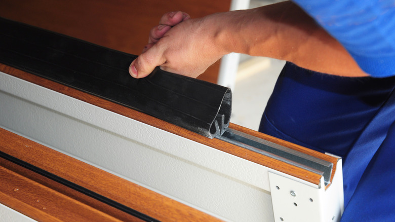 person installing garage door seal