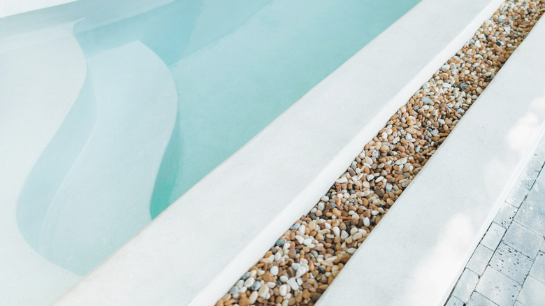 A swimming pool with a border of decorative river rocks.